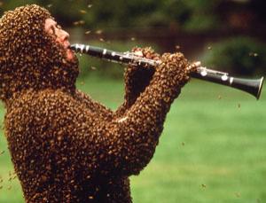 beekeeper coverd in bees playing a clarinet