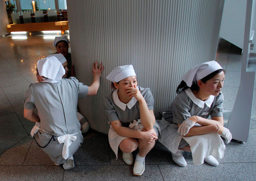 Click to enlarge Hotel employees squat down