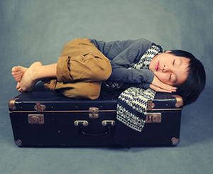 child_sleeping_on_suitcase.jpg