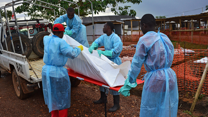 Sierra Leone government burial team members load the body of an Ebola victim onto a truck at an MSF facility in Kailahun, on August 14, 2014.