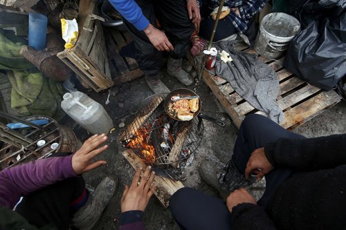 Migrants prepare their food