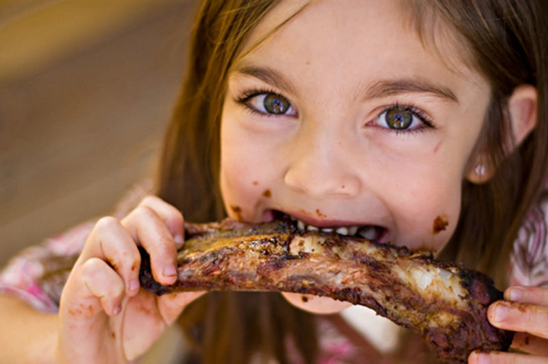 young girl eating meat