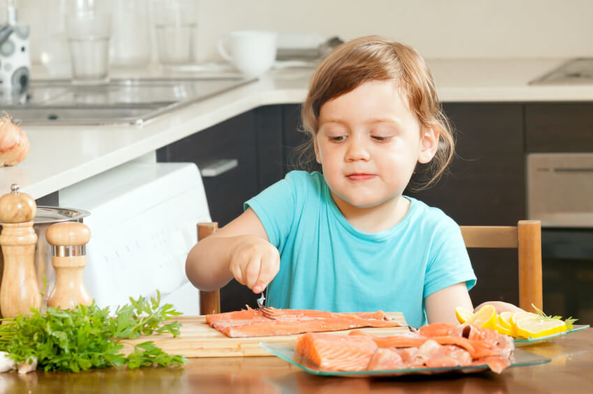 young girl eating salmon
