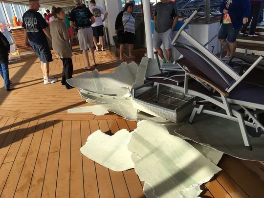 Passengers walk around debris on the top deck of Royal Caribbean's Anthem of the Seas on Feb. 8, 2016