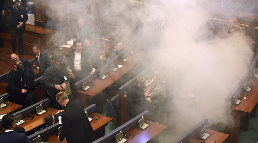 Members of the parliament disperse after a tear gas were thrown by opposition lawmakers during a extraordinary session to elect Kosovo's new President at the parliament in Pritsina on February 26,2016