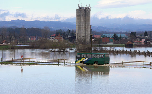 A bus drives along a flooded road near Pozega, some 150 kilometers south of Belgrade, Serbia, Monday, March 7, 2016.