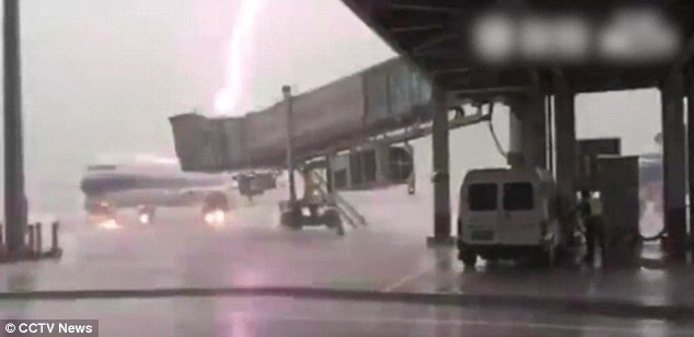 The bolt of lightning makes the plane, which was parked at the airport, flash a vivid purple