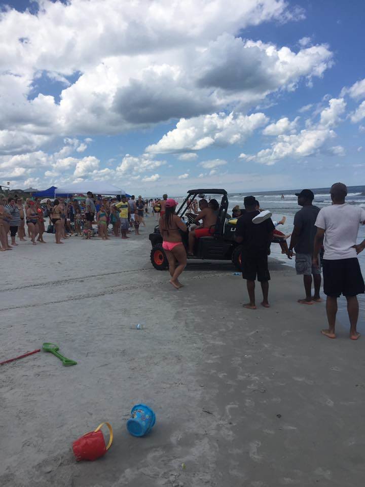 Beachgoers gather after a shark bit a 13-year-old boy at Neptune Beach, Florida. 