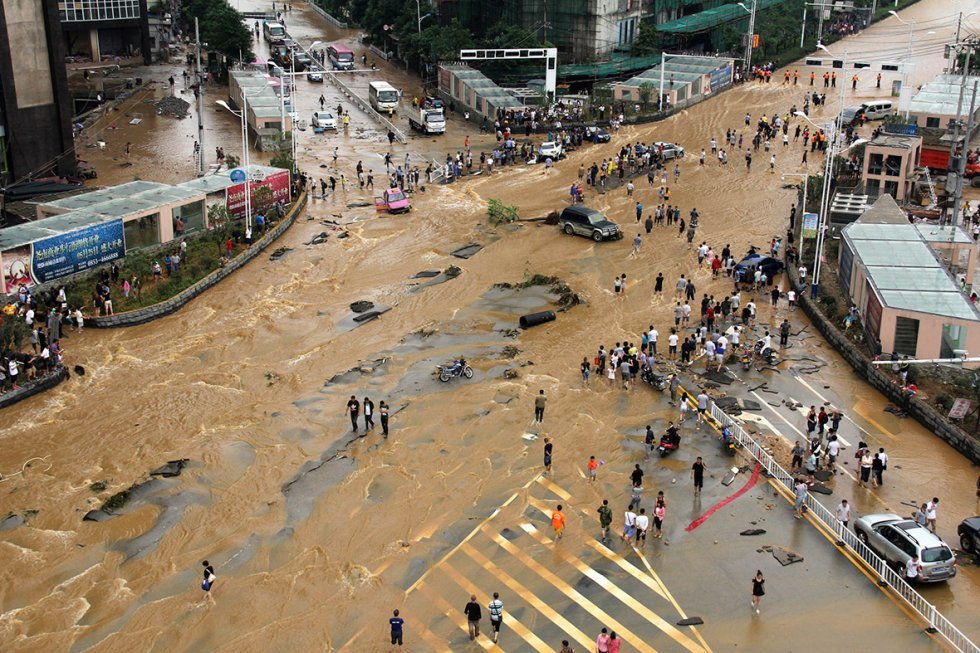 Vehicles come to a standstill at a flooded crossroad in Pingba, Guizhou province, China
