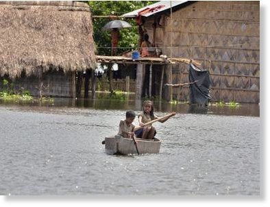Children use a boat in a village near Kaziranga National Park. seven people have died so far in the floods affecting the state.