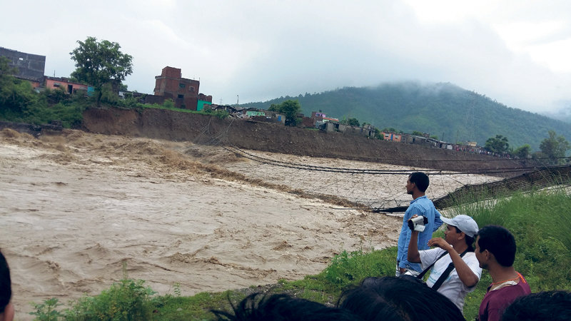 The Tinaun River swept away a suspension bridge that linked Devinagar and Buddhanagar in Rupandehi district Tuesday afternoon.