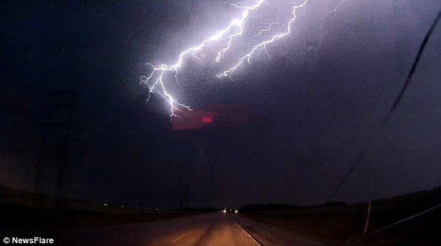 In the video the driver can be heard screaming as he cruises into the path of the lightning storm