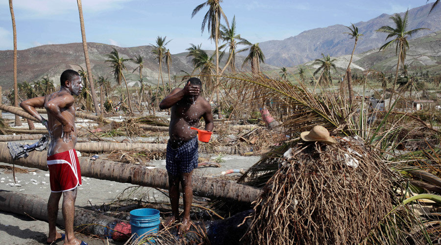 Men take a bath next to trees downed by Hurricane Matthew in Coteaux, Haiti, October 9, 2016. Andres Martinez Casares/Reuters