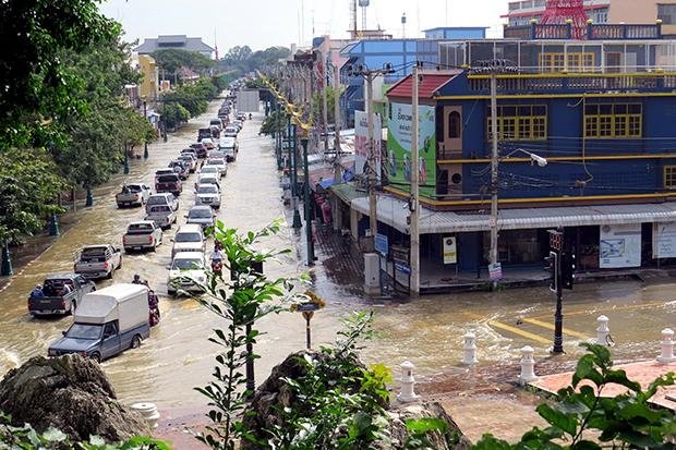 Water from the rain swollen Phetchaburi River flows through downtown Phetchaburi on Wednesday morning. All roads in the town were flooded.