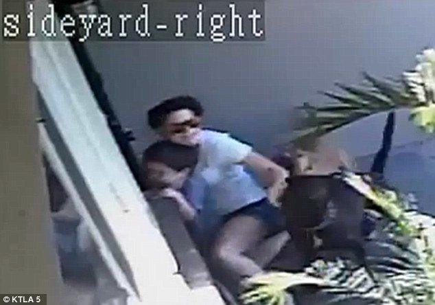 Shocking attack: Surveillance footage from outside the Anaheim home show the mother attempting to fight off the two dogs at her front door, while protecting her son 