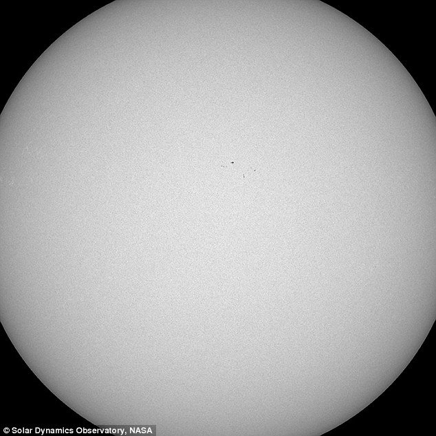 handful of barely-visible spots on the surface of the sun
