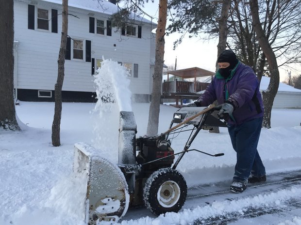 Man snowplowing sidewalk
