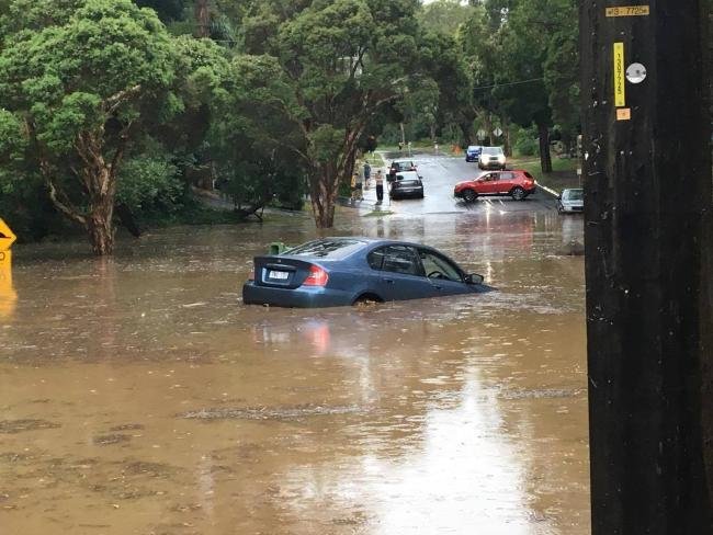 A car submerged in floodwaters on the corner of Station St and McNicol Rd in Belgrave. 