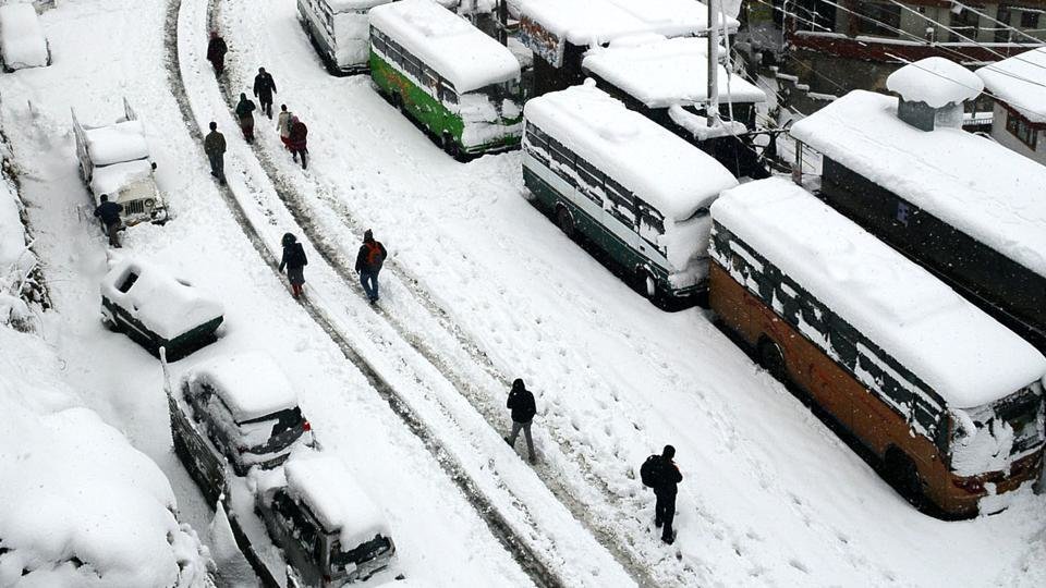 People walking on the snow covered road at Sanjauli, Shimla on Saturday. 