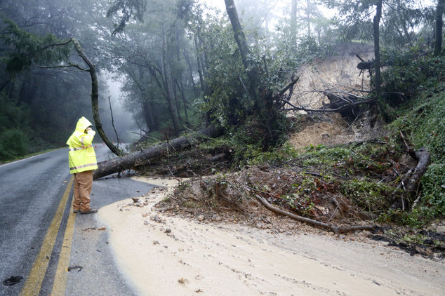 A Santa Clara County Roads and Airport Department worker responds to the scene of downed tree and mudslide on Summit Road in the Santa Cruz Mountains, Calif., Sunday, Jan. 8, 2017.