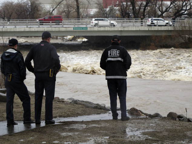 Sparks firefighters monitor the rising Truckee River, Sunday, Jan. 8, 2017, where it runs near the Grand Sierra hotel-casino along a line that divides the cities of Reno and Sparks, Nev. 
