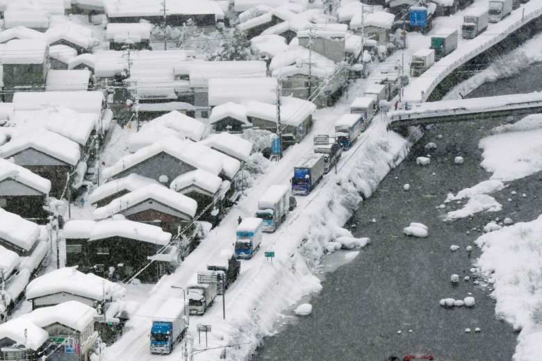 Vehicles stuck after heavy snow blanketed the town of Chizu in Tottori prefecture yesterday. Japanese troops were mobilised to help dig out the vehicles.