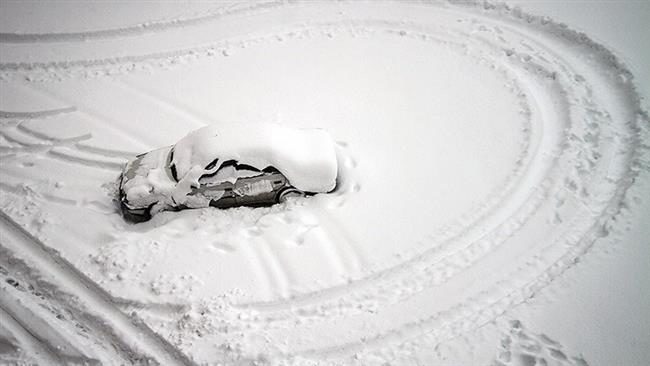 This February 13, 2017 photo released by Iran's Tasnim news agency shows a car covered with snow in the central Iranian city of Arak.