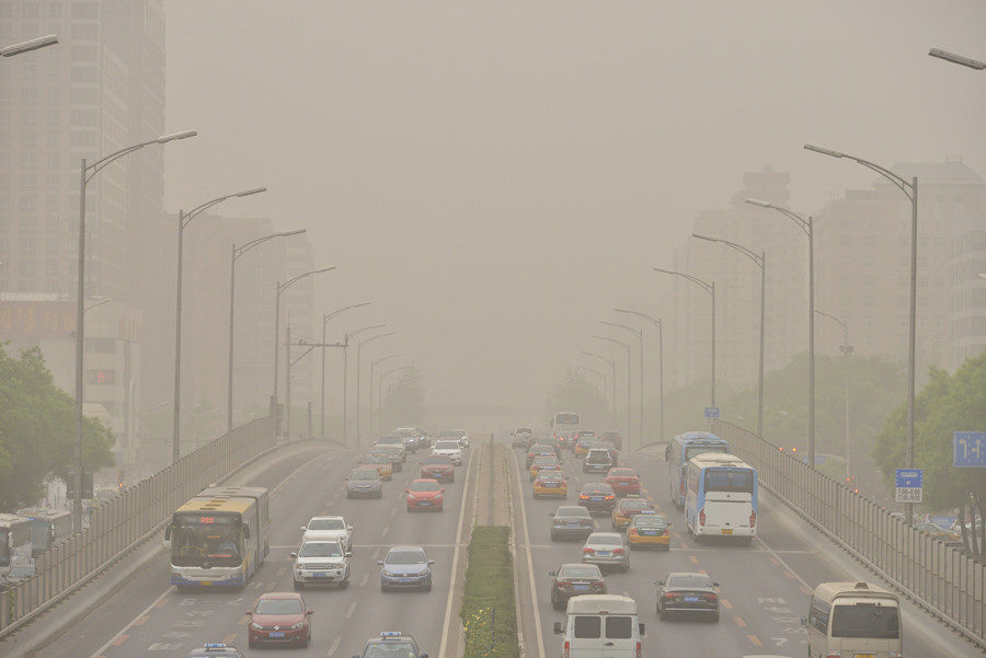 Vehicles are seen on roads during a dust storm in Beijing