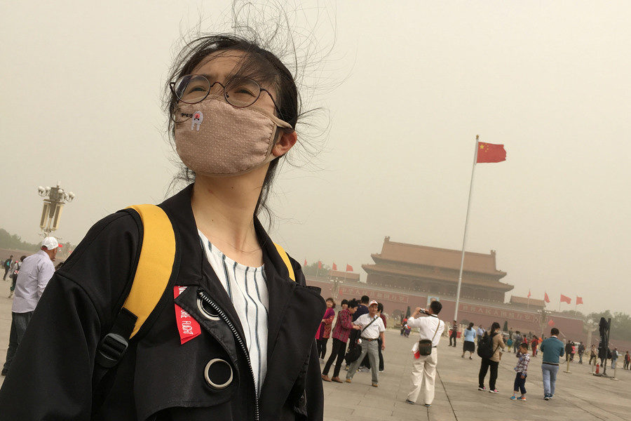 People visit Tiananmen Square as a sandstorm hits Beijing