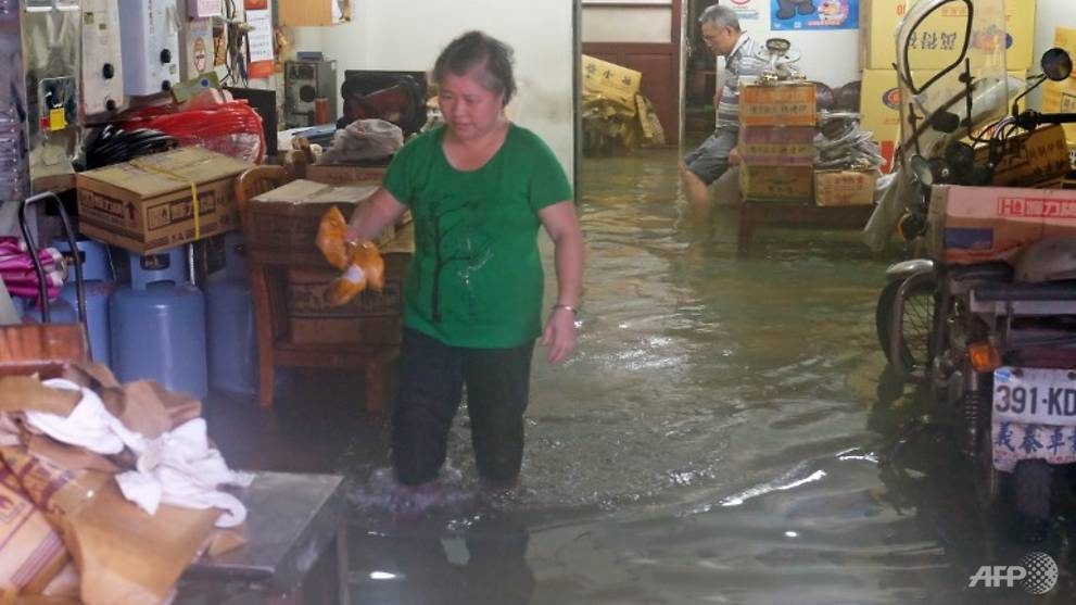 Local residents stay in their flooded home during heavy rain in Jinshan, New Taipei 
