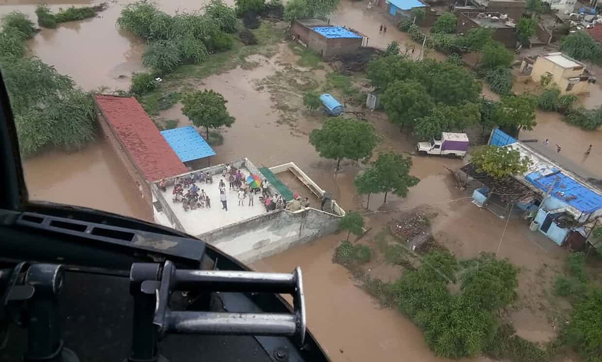 Flood victims, including a patient needing kidney dialysis, await an airlift from a rooftop in Abiyana village, Gujarat after monsoon floods hit