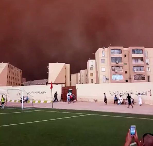 The clip begins with a group of young men playing football in Ain Oussera, Algeria