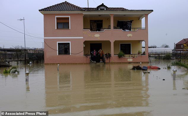 A couple stands in a flooded home after heavy rainfall in the village of Hasan, about 25 kilometers (15 miles) north of Tirana, Friday, Dec. 1, 2017.