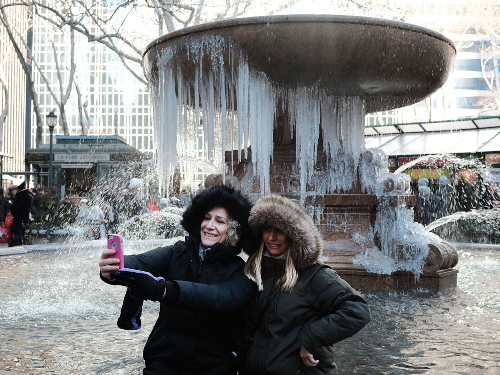 Women take a selfie in front of a frozen fountain in Bryant Park, Manhattan