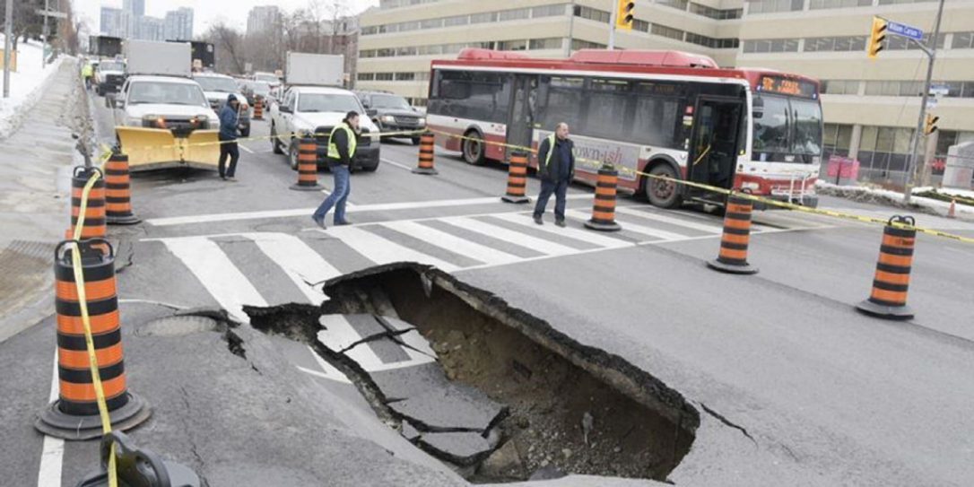 City work crews attend at the scene of a sinkhole in the southbound lanes of Yonge St., just south of Highway 401, at William Carson Cres