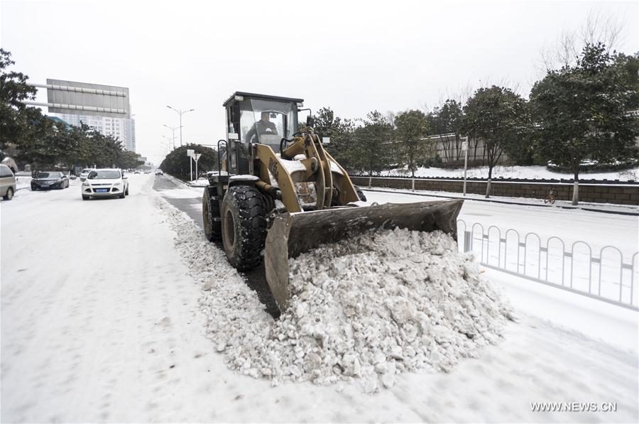 Staff worker cleans road after snowfall in Wuhan City, capital of central China's Hubei Province, Jan. 27, 2018.