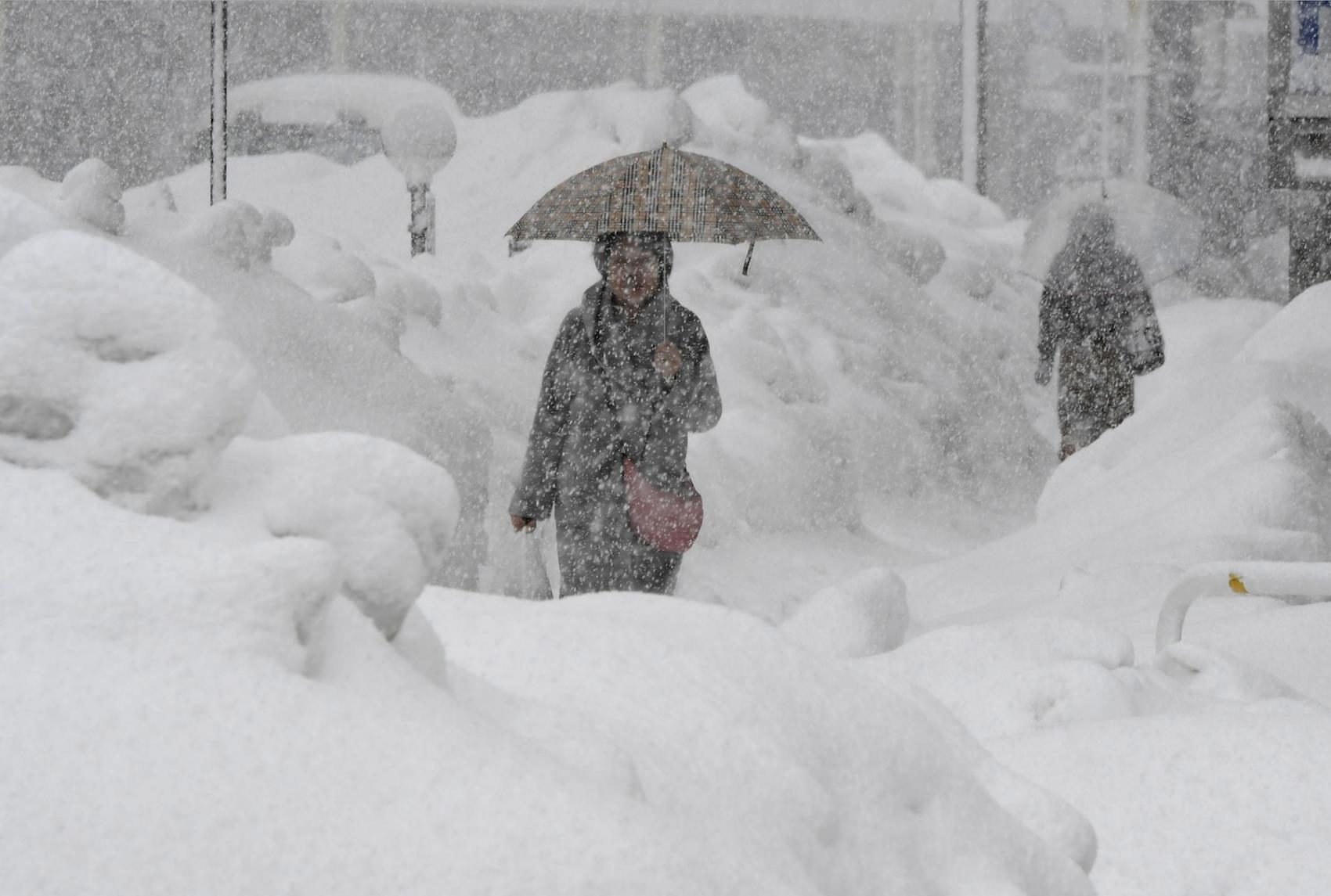 A woman walks during heavy snow in Fukui on Monday.