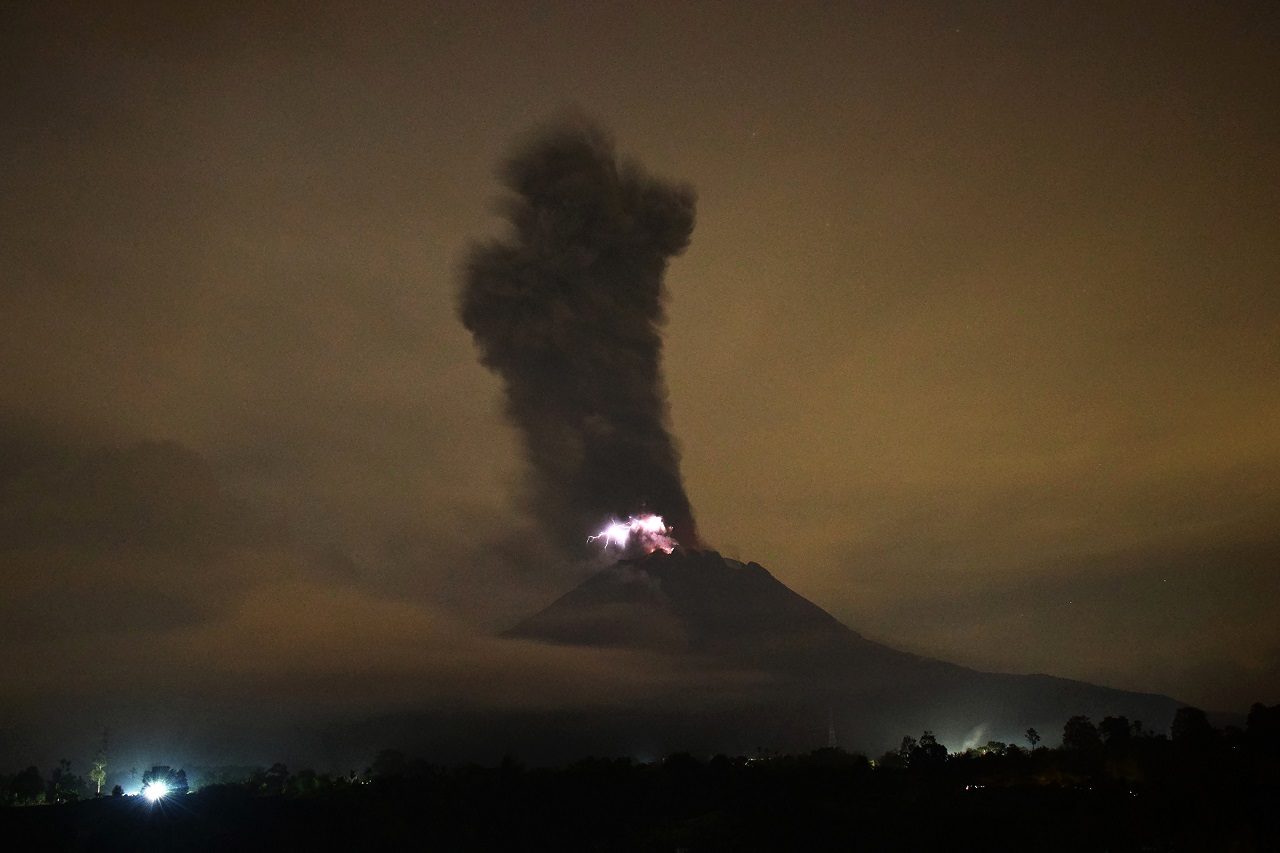 This picture taken on May 20, 2018 shows the Mount Sinabung volcano spewing ash into the air and lightning from its crater in Karo.