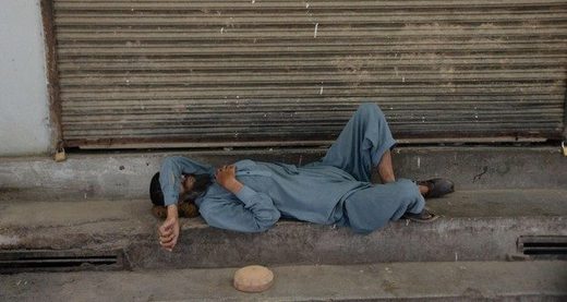 An Afghan Muslim man sleep in front of a shop