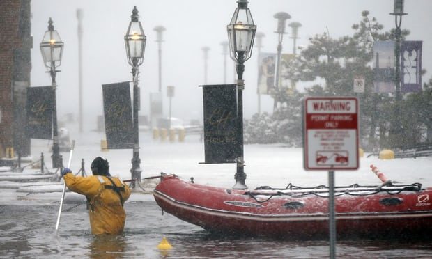 A firefighter wades through waters from Boston Harbor
