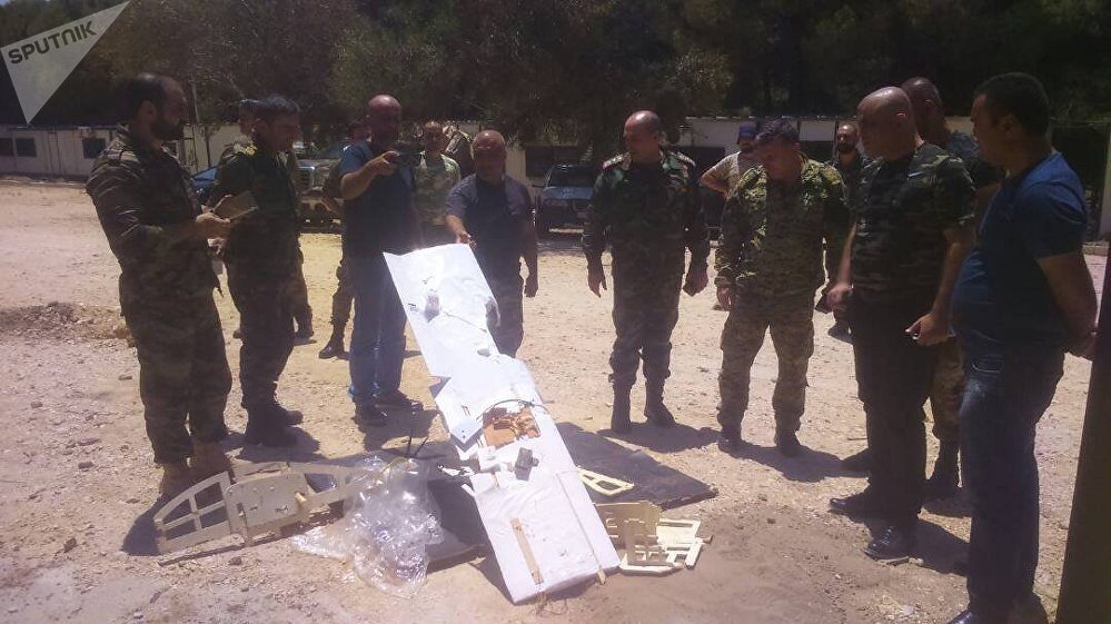 Syrian servicemen are seen near a downed drone