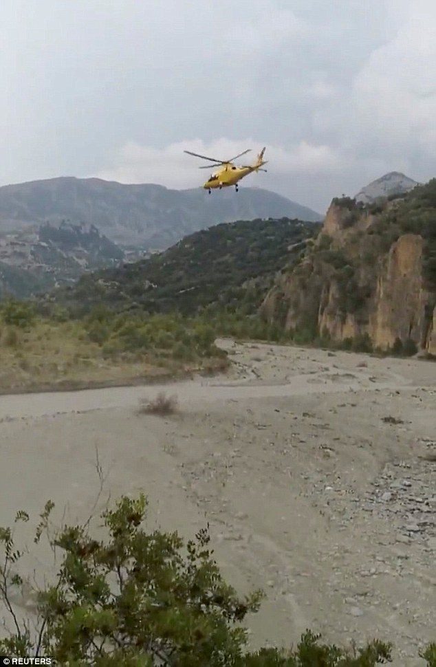 A rescue helicopter takes off after several people were killed in a mountain gorge flooding