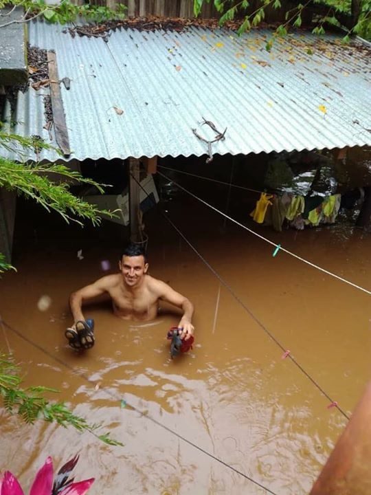 Click to enlarge A man salvages belongings after flooding