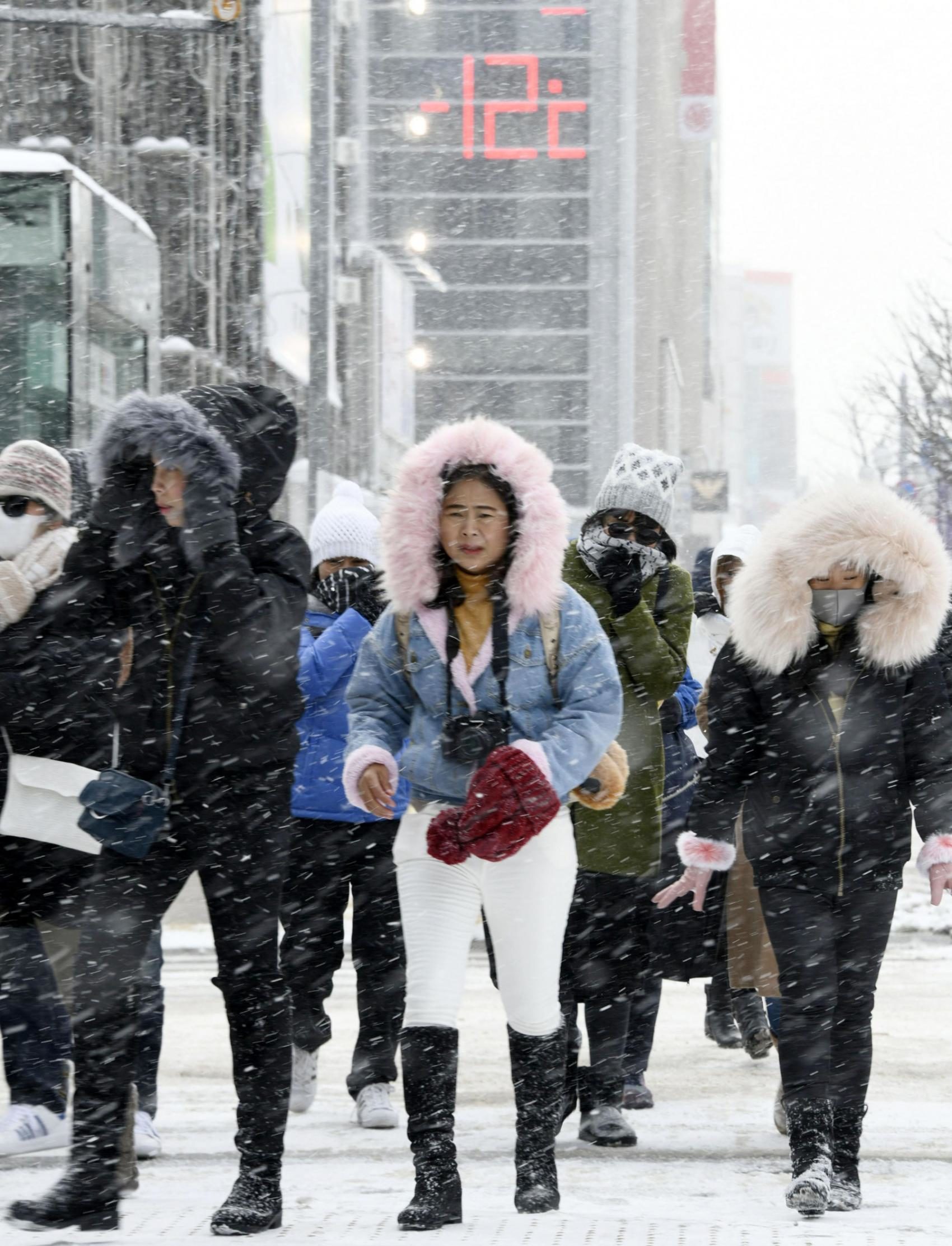 People walk in Sapporo on Friday as the