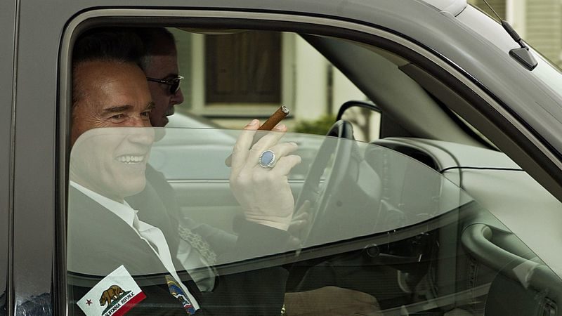 Arnold Schwarzenegger holds a cigar