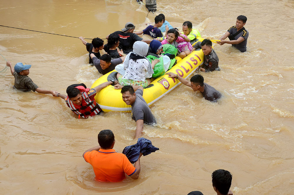 People are evacuated from the Bung Permai residential complex in Makassar, South Sulawesi, during heavy flooding on Wednesday. Floodwaters from the overflowing Tello River reached depths of up to 1 meter.