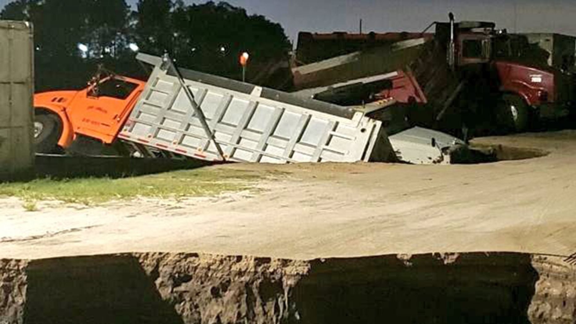 Trucks can be seen sticking out of a possible sinkhole in Florida early Wednesday.