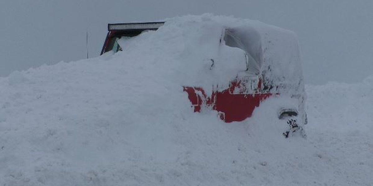 A Jeep is buried in snow in a town of Adams parking lot