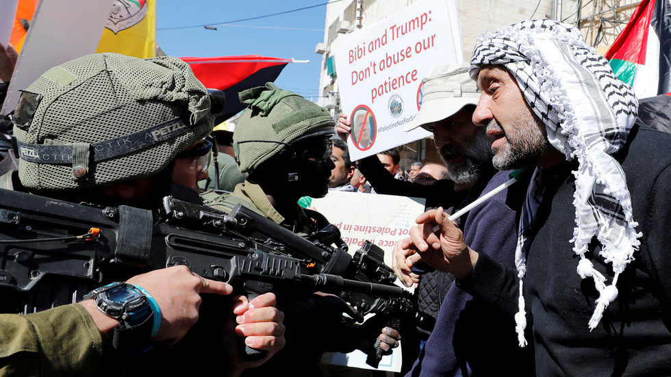 Palestinians argue with Israeli forces during a protest in Hebron