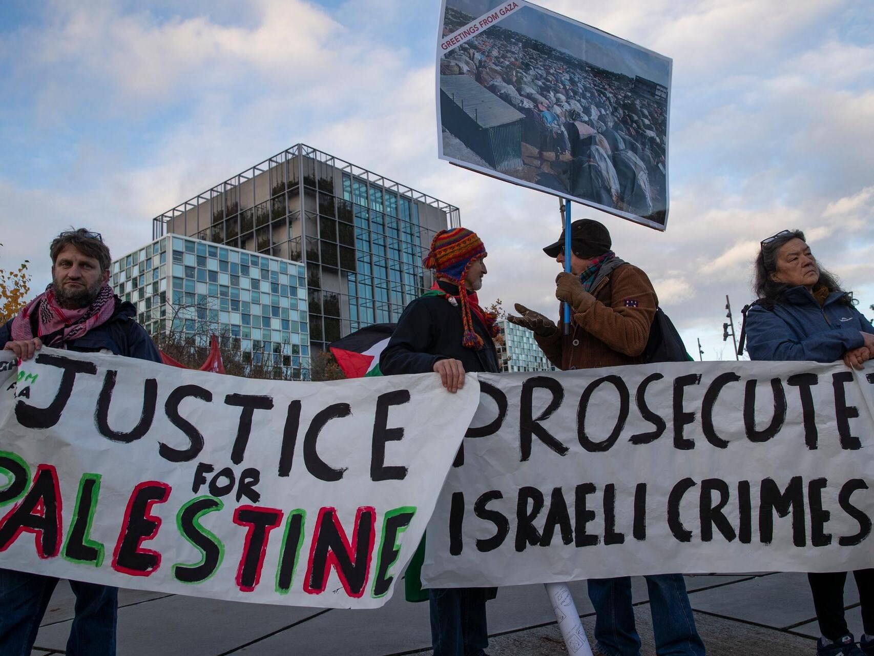 Demonstrators carry banners outside the International Criminal Court